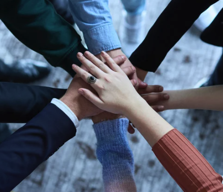 Diverse hands joined together, symbolizing unity and collaboration in achieving philanthropic goals through donor-advised funds.